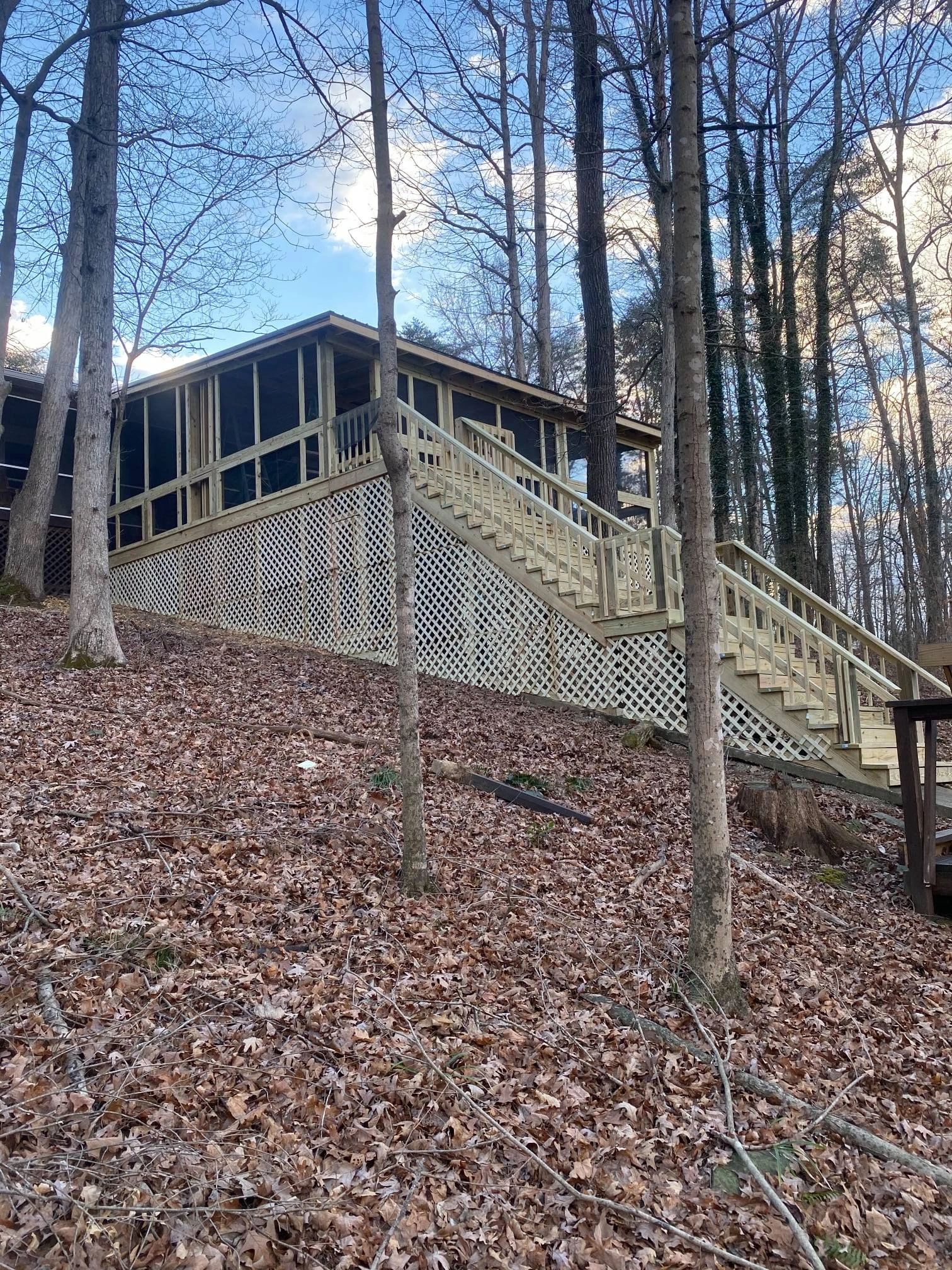 Covered lakefront deck with cedar framing, metal roof, and stairwell to dock — Nolin Lake, Kentucky