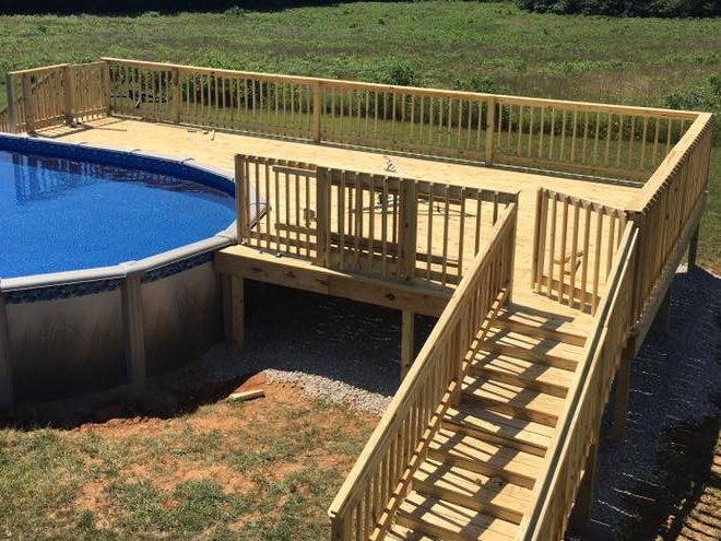 New pressure-treated deck with railings and a long stair built around an above-ground pool in the Rough River Lake area, KY