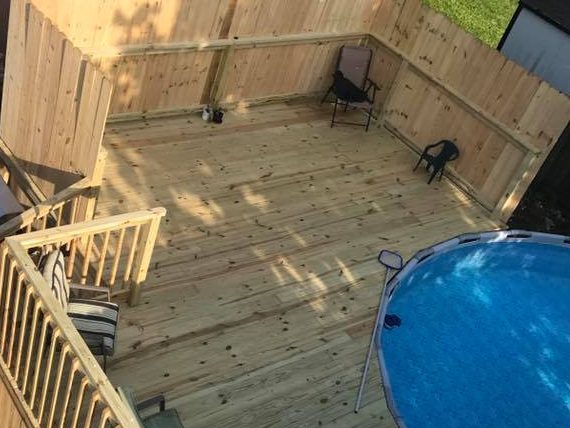 Pressure-treated pool deck with a tall privacy fence, railing and patio chairs, seen from above — Nolin Lake area, KY
