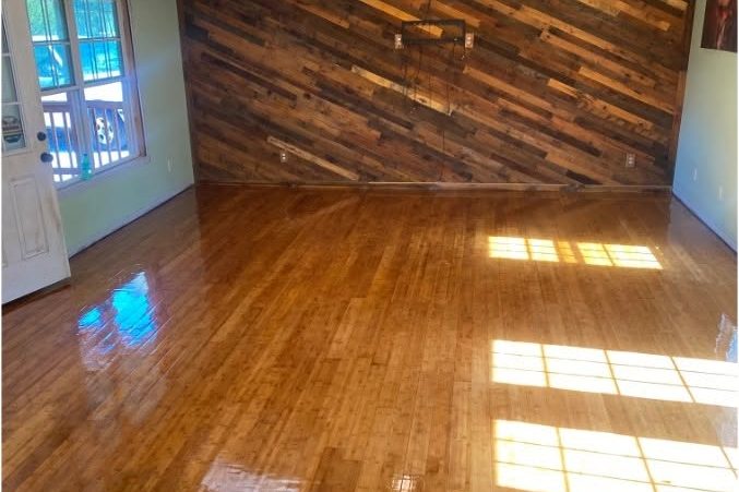 Room with newly finished hardwood flooring and a diagonal reclaimed-wood accent wall — western Kentucky