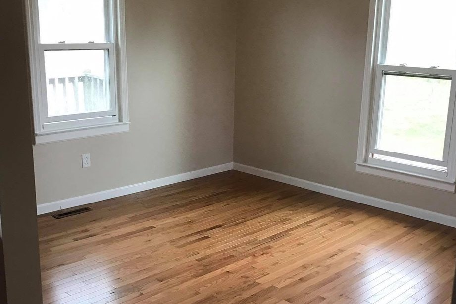 Newly installed hardwood floor in a freshly painted room with white trim and double-hung windows in Leitchfield, KY