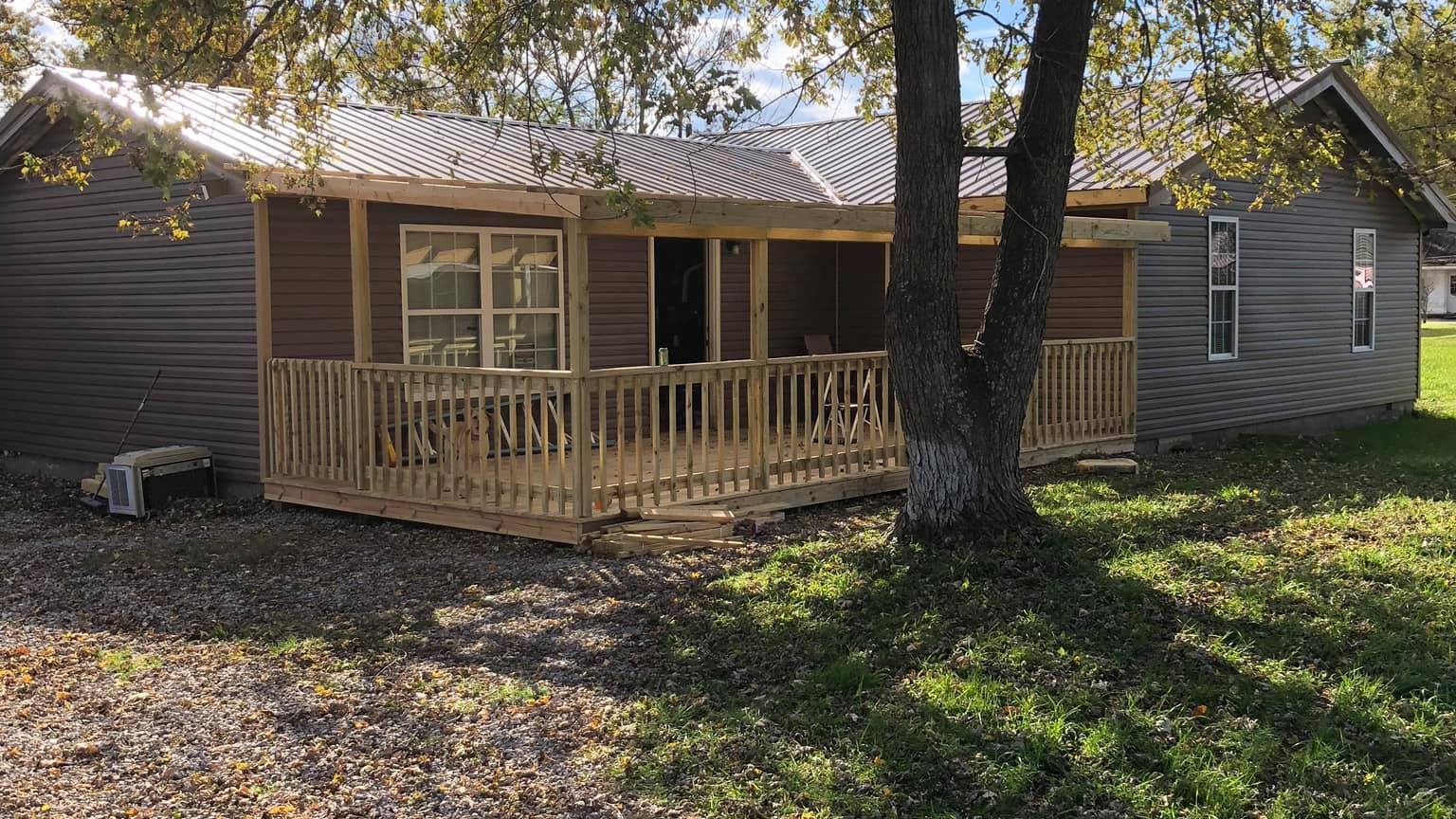 House with a new wood front porch and railing, shaded by a large tree — Nolin Lake, Grayson County, Kentucky