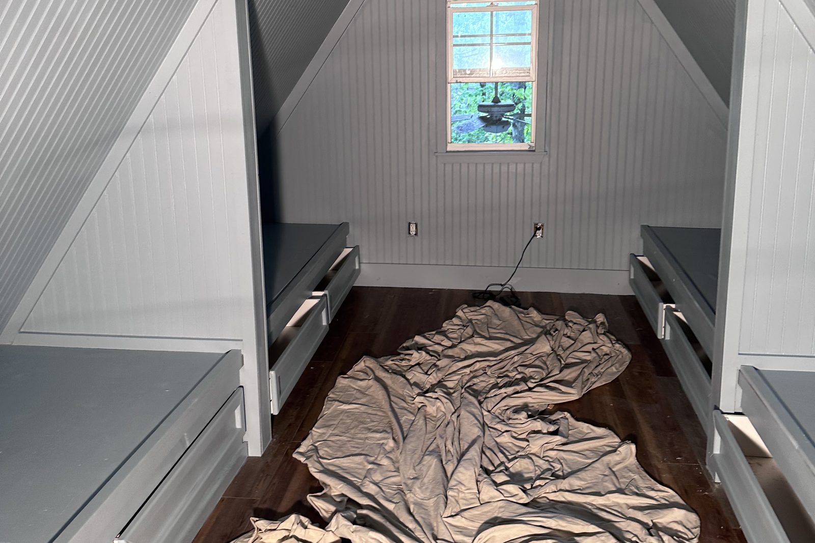 Attic converted into a bunk room with painted beadboard walls and built-in bunks on both sides — Grayson County, KY